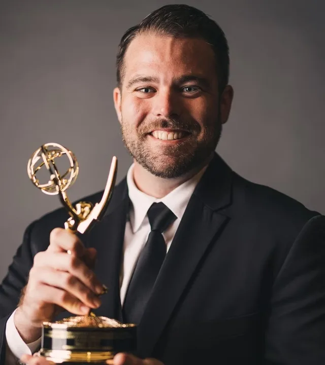 Editor Christopher Hoerdermann holding an Emmy award